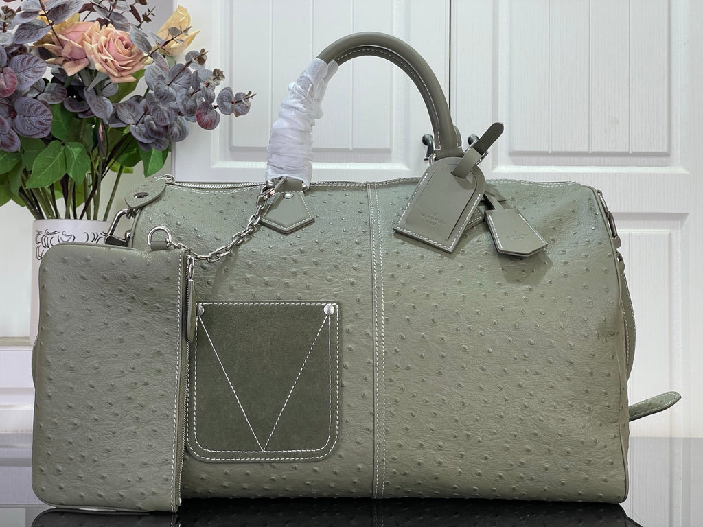 Louis Vuitton bag in olive green with top handles, front pocket, and chain detail