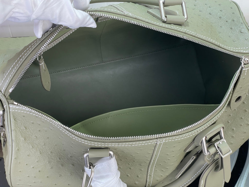 Open sage green Louis Vuitton bag interior with metal clasp and lining
