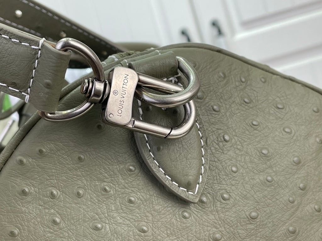 Louis Vuitton olive green bag with metal D-ring hardware and embossed texture