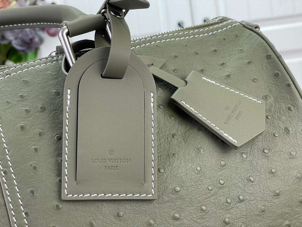 Louis Vuitton olive green bag with stitched leather label and luggage tag