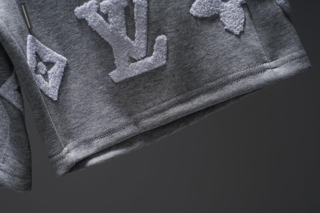 Gray pants with appliqué letters near hem