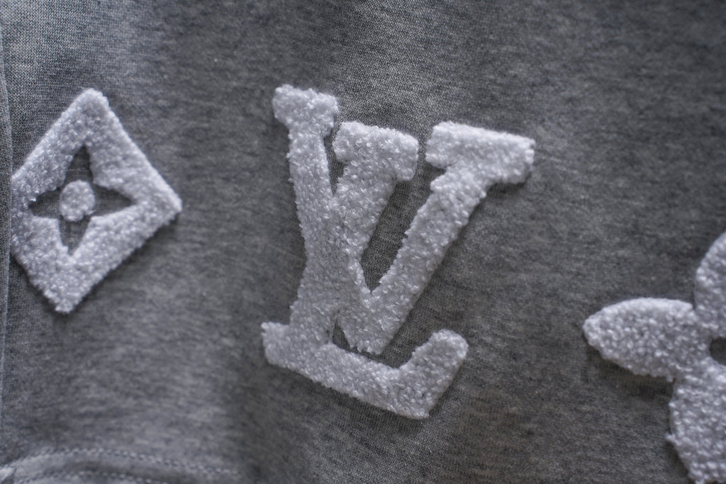 Gray sweat shorts fabric with large embroidered LV monogram motifs