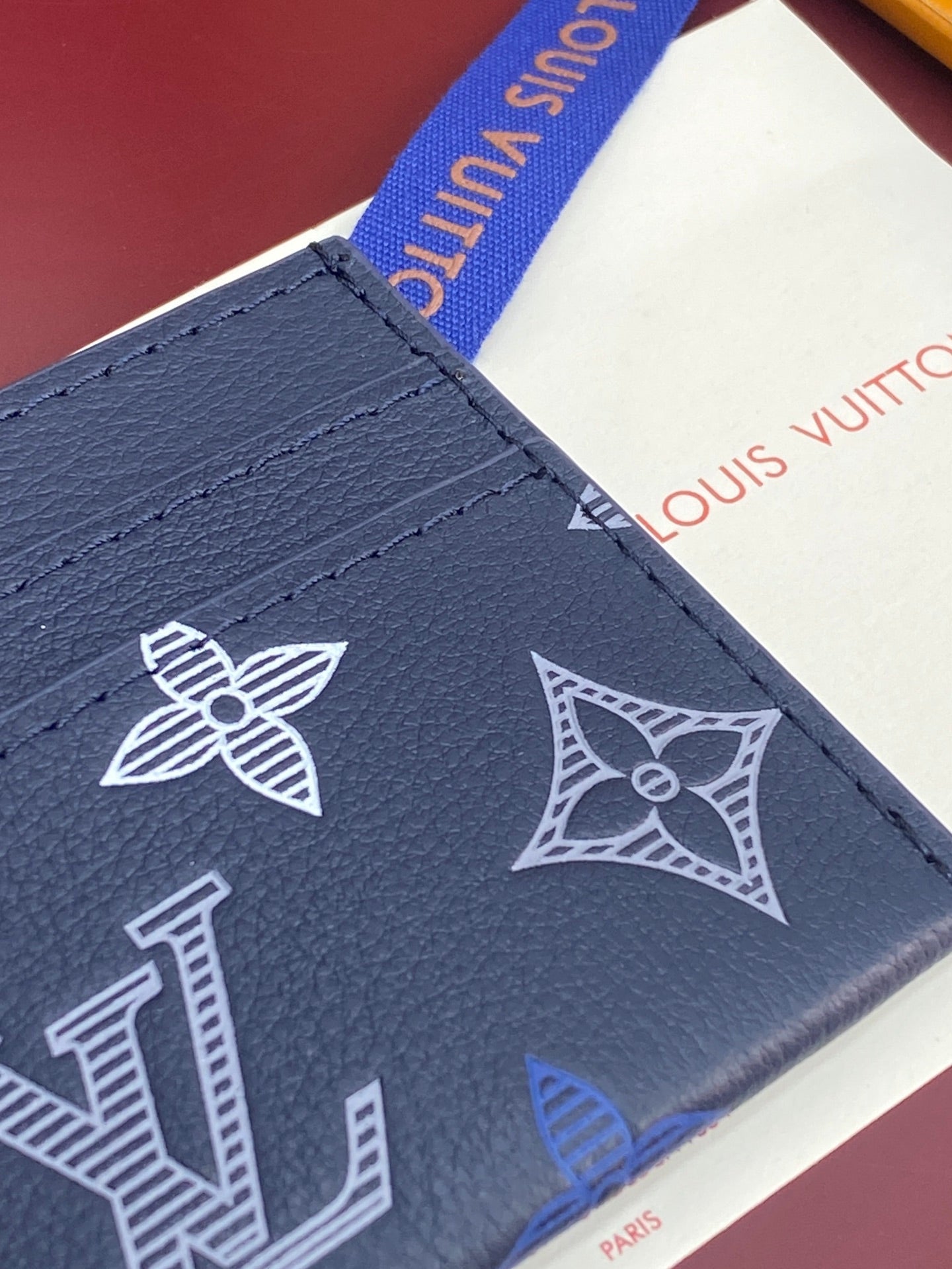 Navy card holder with bow-and-star monogram pattern and top seam