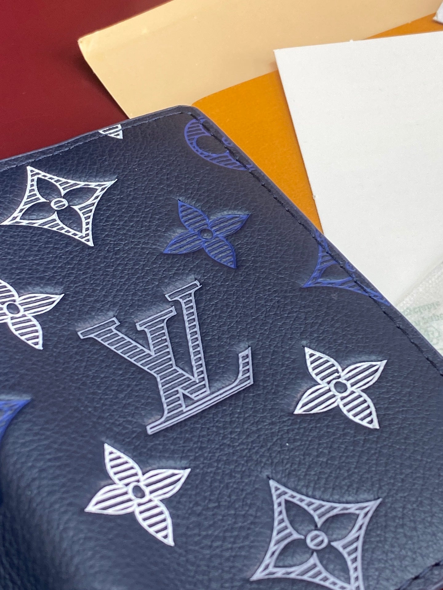 Blue Louis Vuitton small bag close-up of LV and butterfly monogram pattern