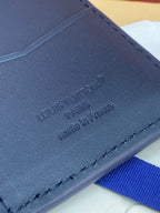 Louis Vuitton blue leather card holder with embossed "Louis Vuitton" and "Paris"
