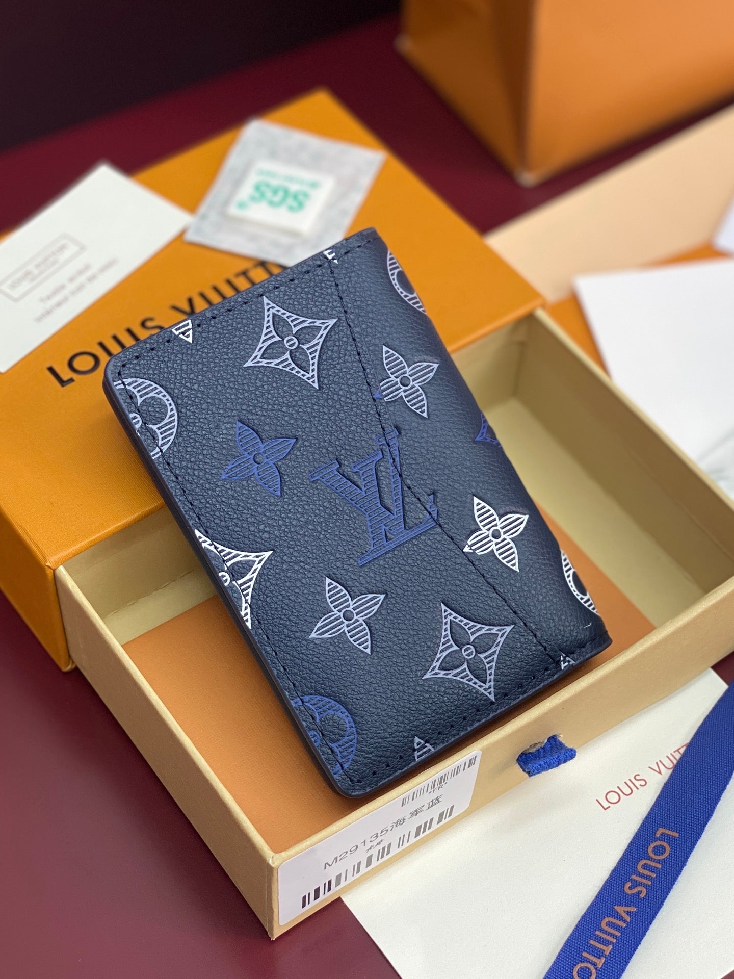 Blue Louis Vuitton small bag with repeating monogram and butterfly motifs, angled view