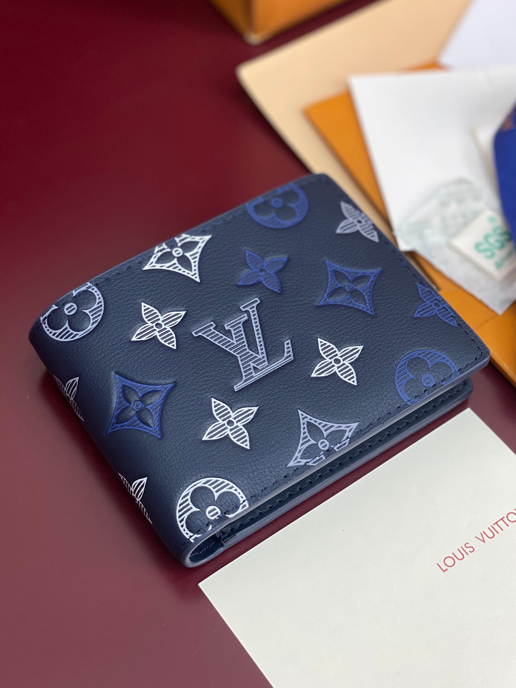 Louis Vuitton blue monogram wallet with patterned exterior, front angled view
