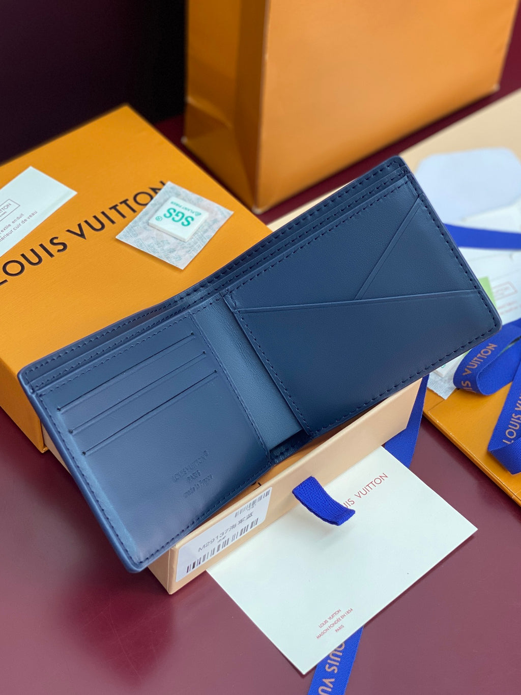 Louis Vuitton blue wallet with multiple card slots, open interior view