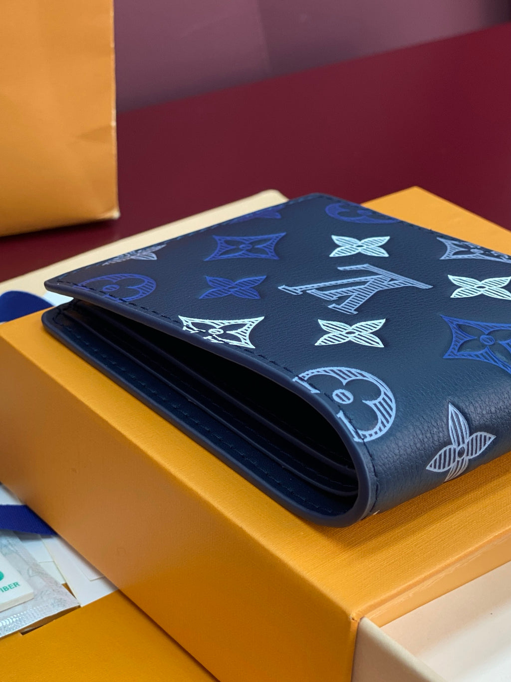 Louis Vuitton small wallet with navy monogram pattern and rolled fold