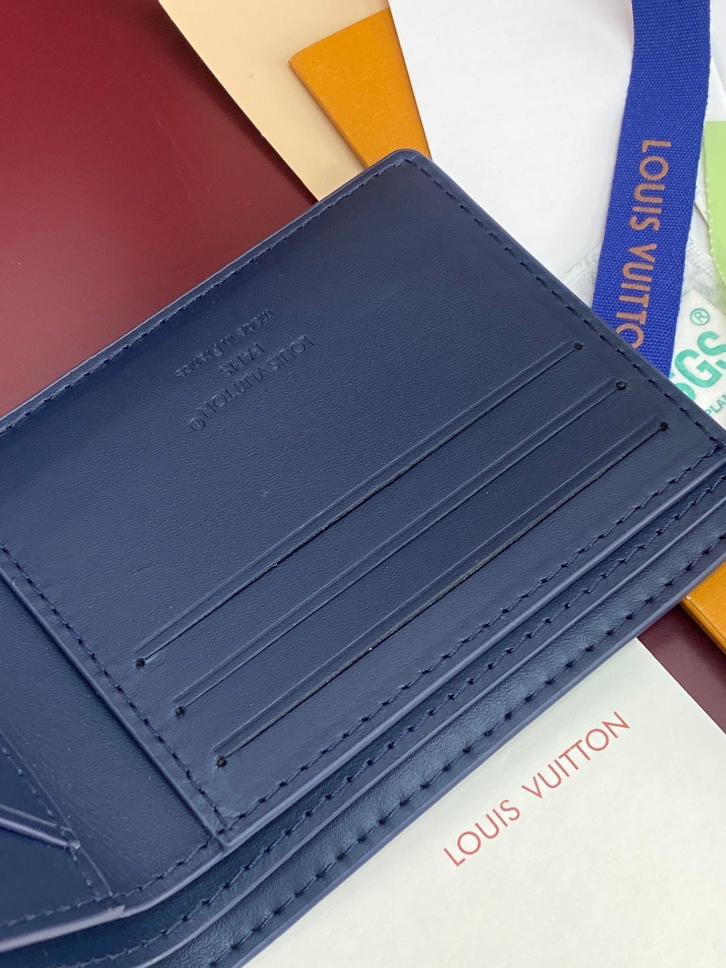 Louis Vuitton small wallet blue leather with multiple card slots and edge stitching
