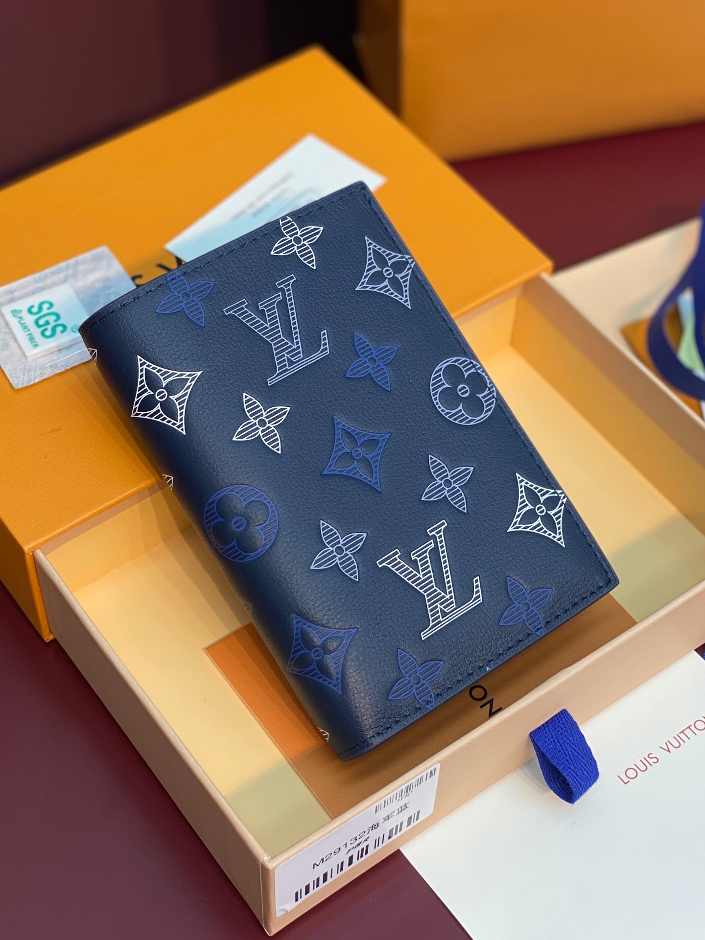 Louis Vuitton card holder in navy blue with monogram pattern and snap closure