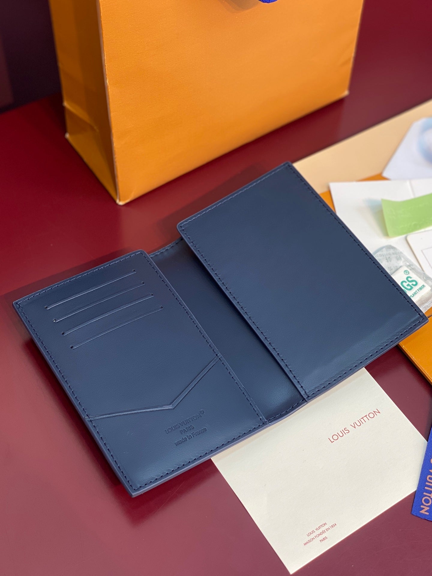 Louis Vuitton card holder open in navy blue with card slots and side panel seams
