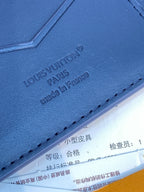 Louis Vuitton small card wallet close-up, embossed 'LOUIS VUITTON' on blue leather
