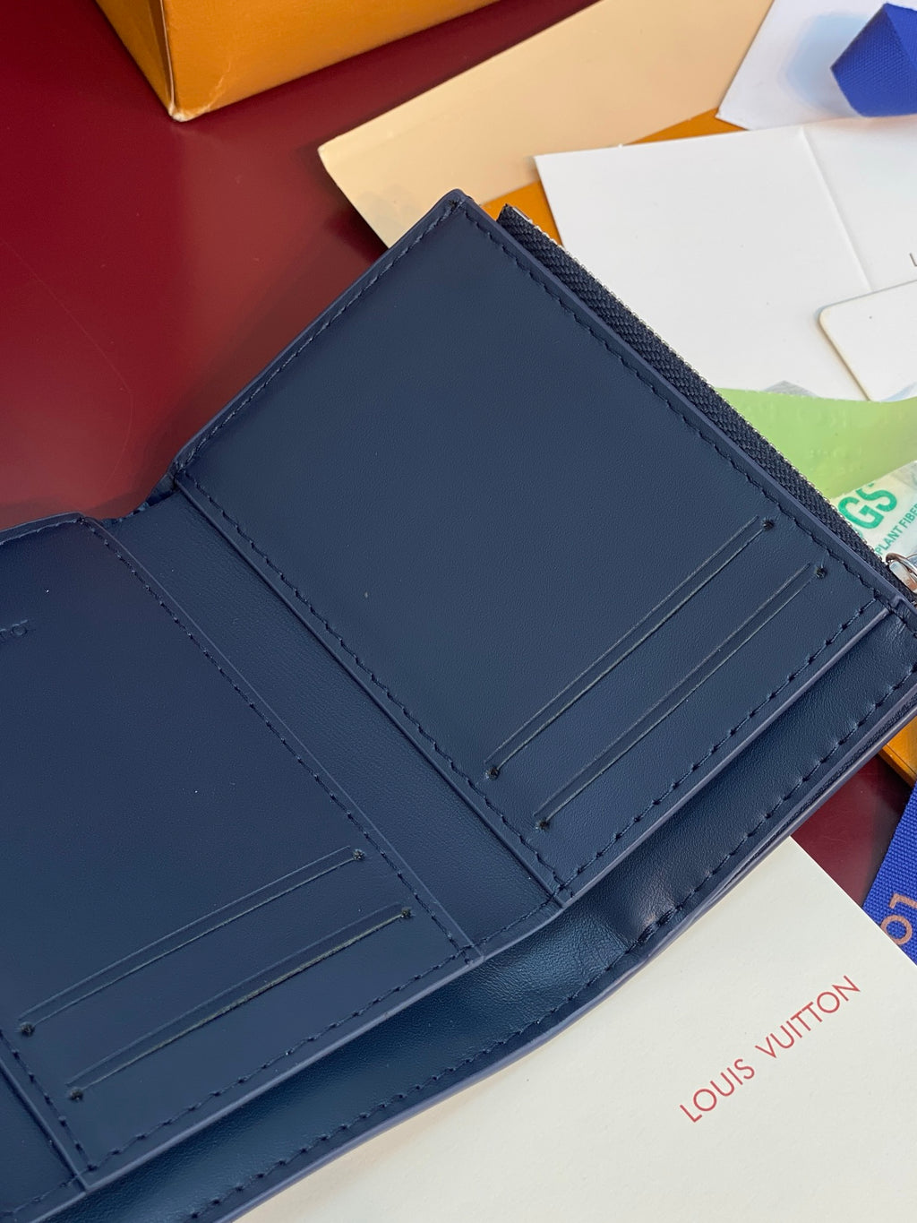 Louis Vuitton leather card holder with dark blue interior card slots and stitching