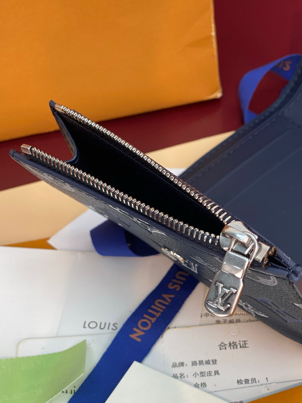 Louis Vuitton zip wallet with silver zipper and dark blue textured exterior
