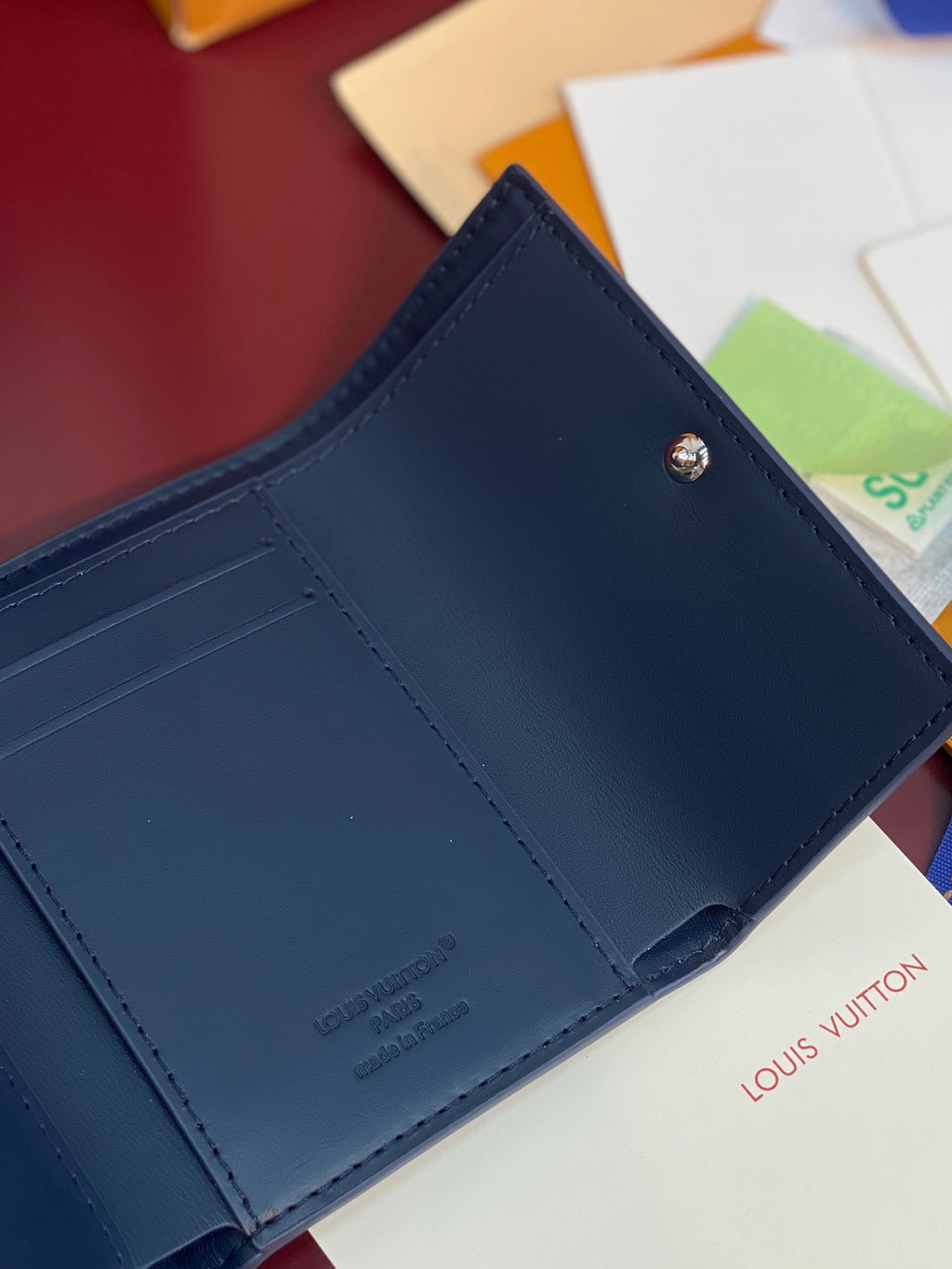 Navy leather wallet interior with stitched edges and snap button