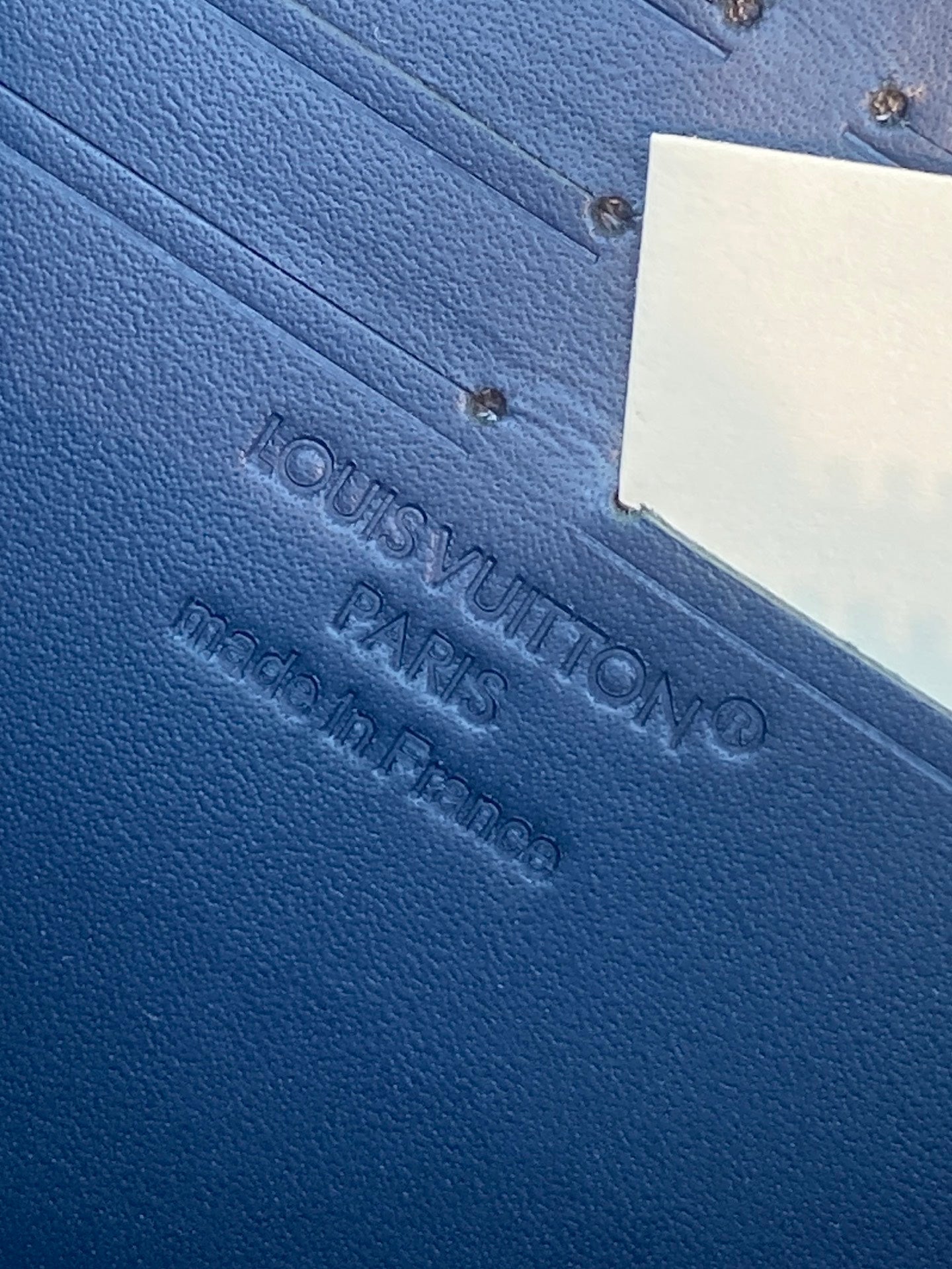 Louis Vuitton blue textured leather wallet exterior with embossed logo and tag