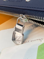 Blue Louis Vuitton small bag zipper pull close-up with metal lock hardware.