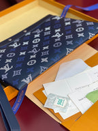 Blue Louis Vuitton small bag with monogram print on top flap, shown with packaging inserts.