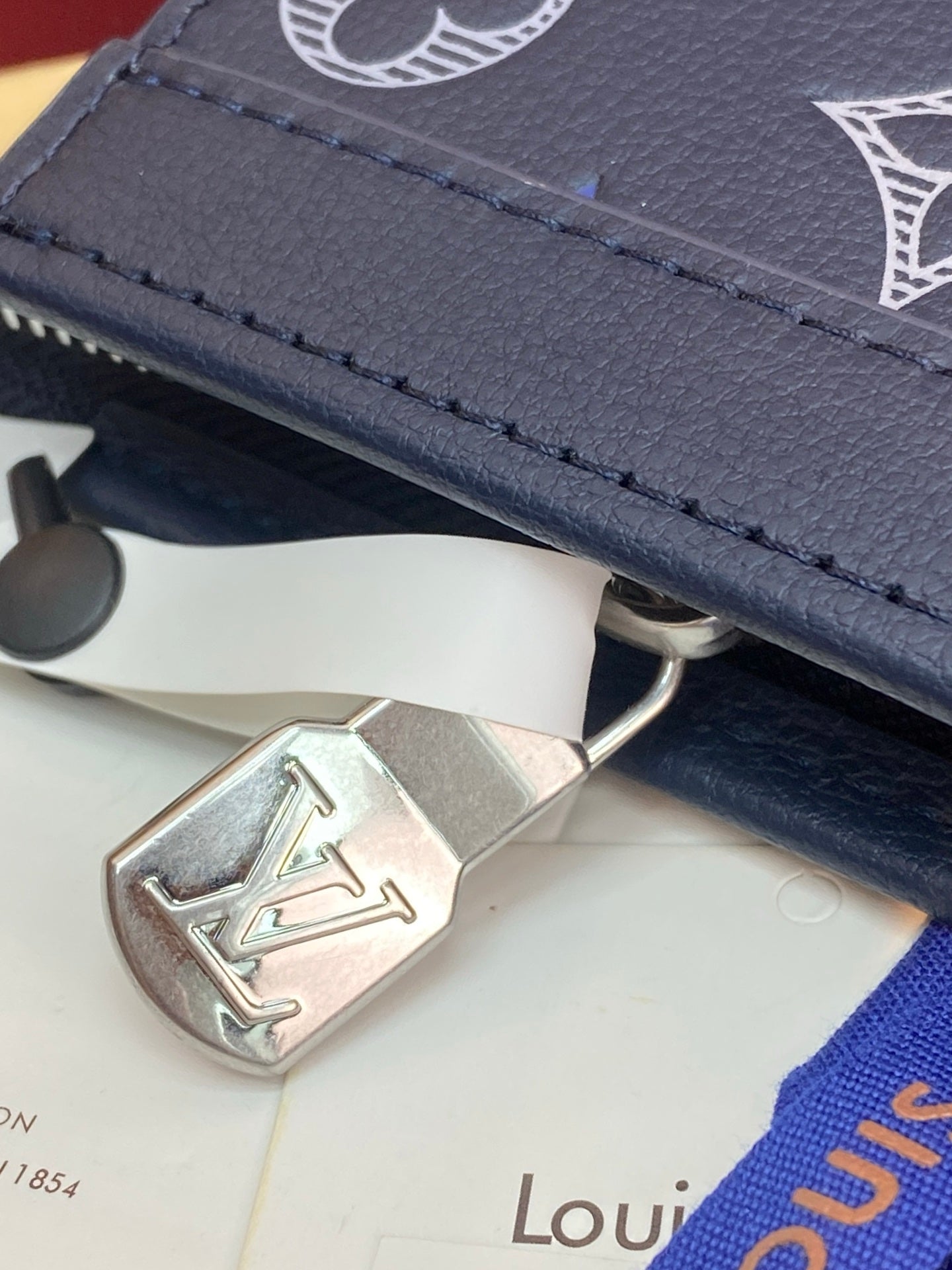 Blue monogram bag clasp with silver-tone metal LV emblem
