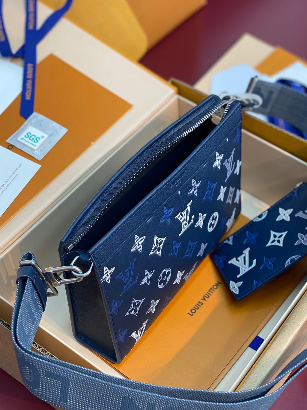 Blue Louis Vuitton small crossbody bag with long strap and white monogram pattern