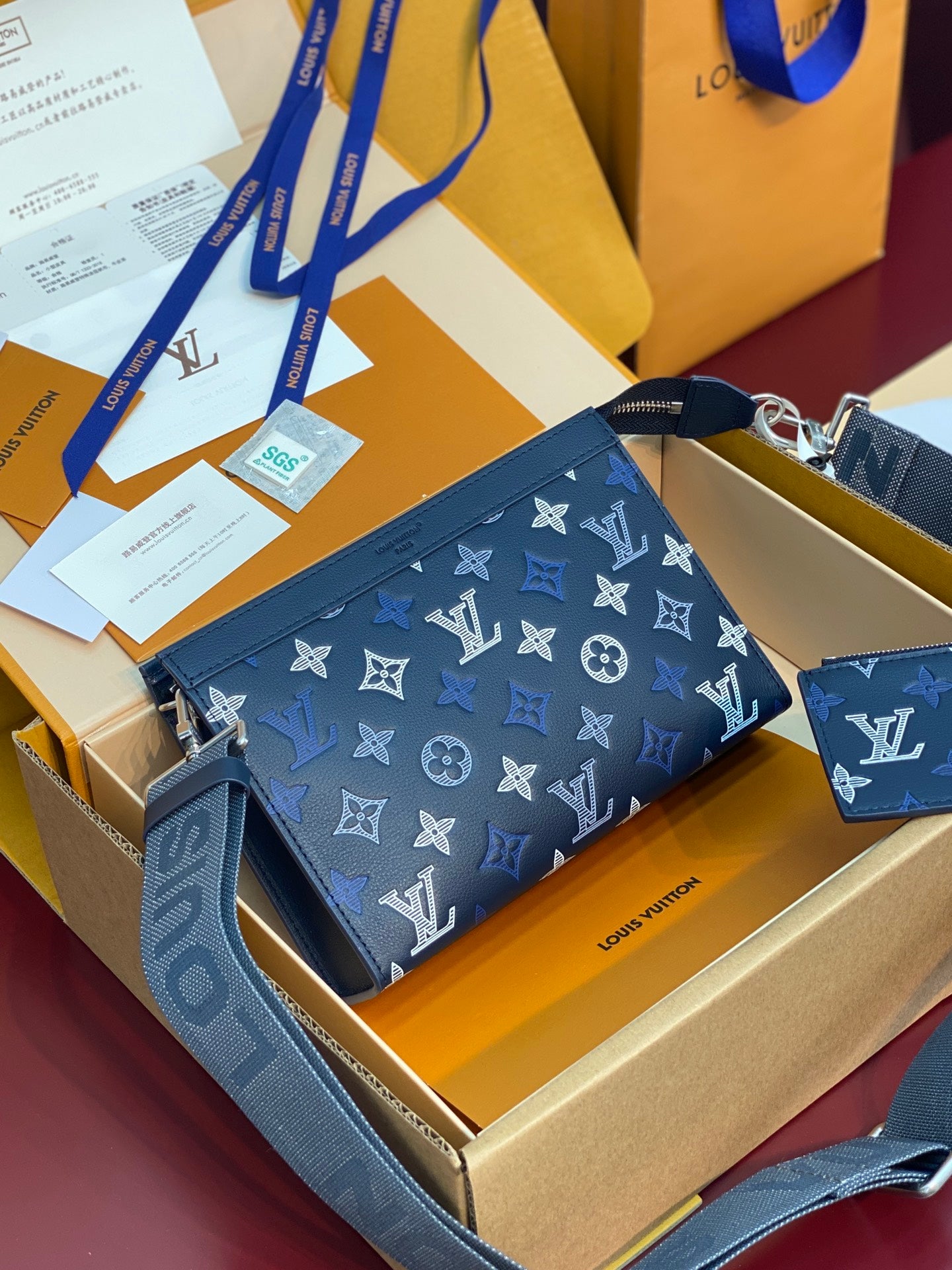 Blue monogram pouch with top zipper, adjustable crossbody strap