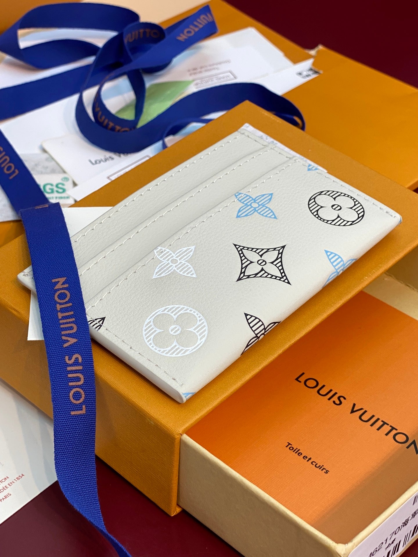 Louis Vuitton small bag with blue-and-white monogram print and blue strap