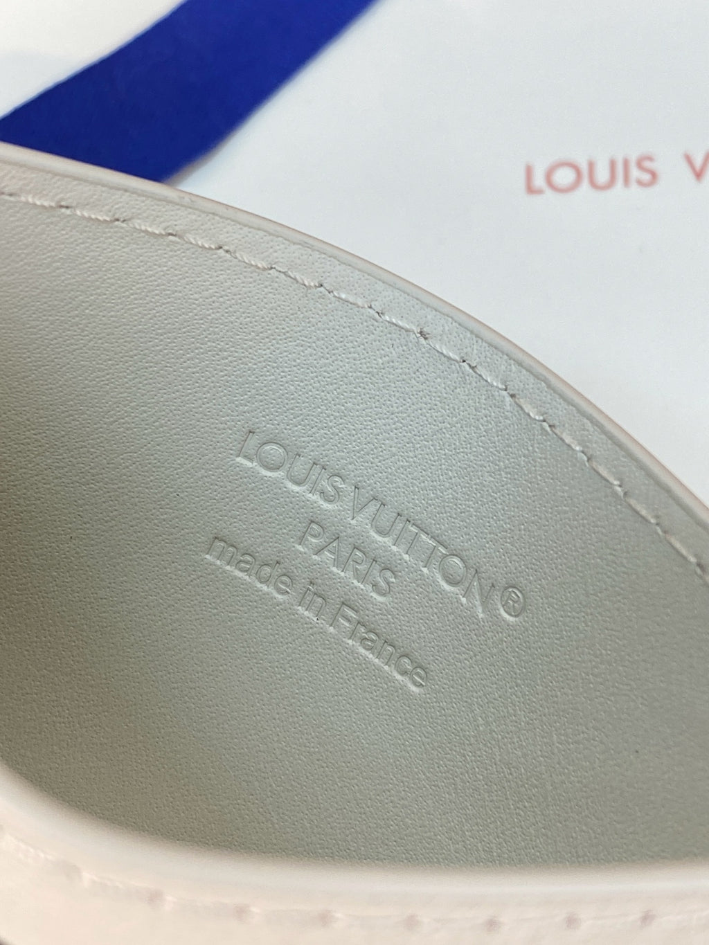 Louis Vuitton small bag embossed logo on light leather panel