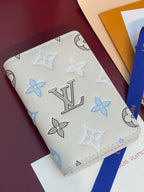 Men's Louis Vuitton small card wallet, angled view of white with blue and black monogram pattern.