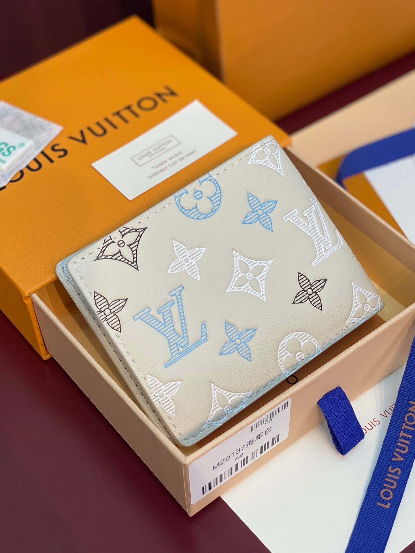 Louis Vuitton small bi-fold card holder, light blue monogram print on white leather