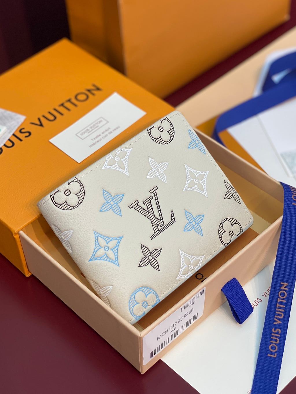 Louis Vuitton wallet with blue Monogram pattern, front flap and snap closure.