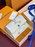 White small wallet with blue monogram pattern and snap closure, card slots visible