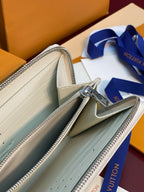 Small zip wallet open with light interior, silver zipper pull and stitched lining.