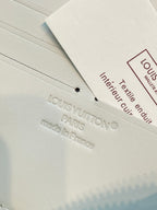 Small wallet care label inside with text and Louis Vuitton marking on tag.
