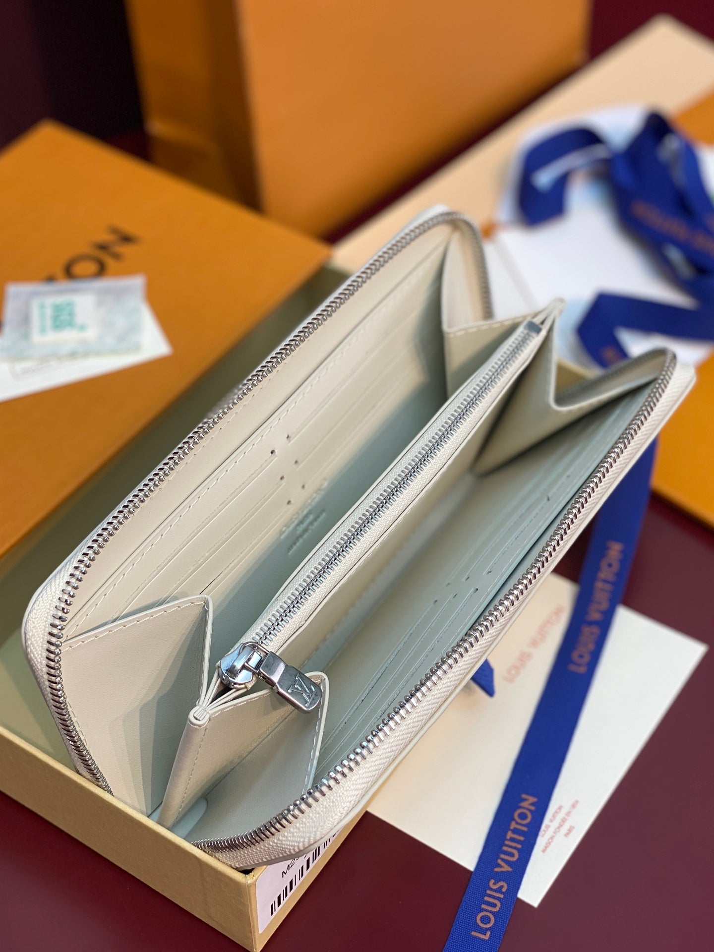 Louis Vuitton monogram zip wallet, open view showing beige interior and card slots