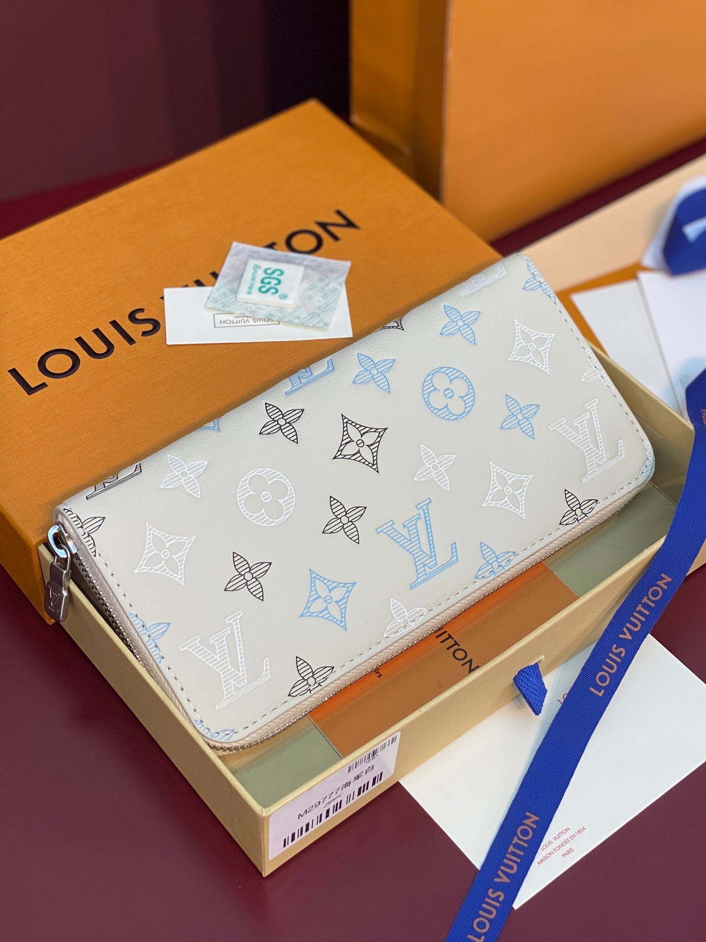 Louis Vuitton monogram zip wallet with blue bow and logo pattern, front view
