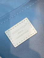 Close-up of blue fabric lining and white leather patch with Louis Vuitton branding.