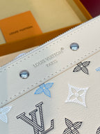 Close-up of white monogram clutch edge with Louis Vuitton embossing and silver snaps.