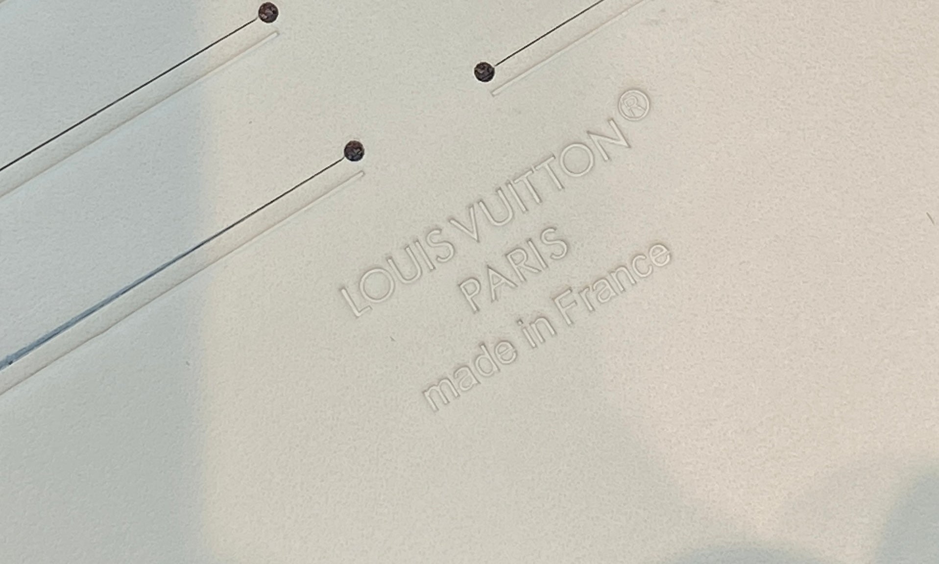Embossed Louis Vuitton Paris made in France label on light monogram canvas