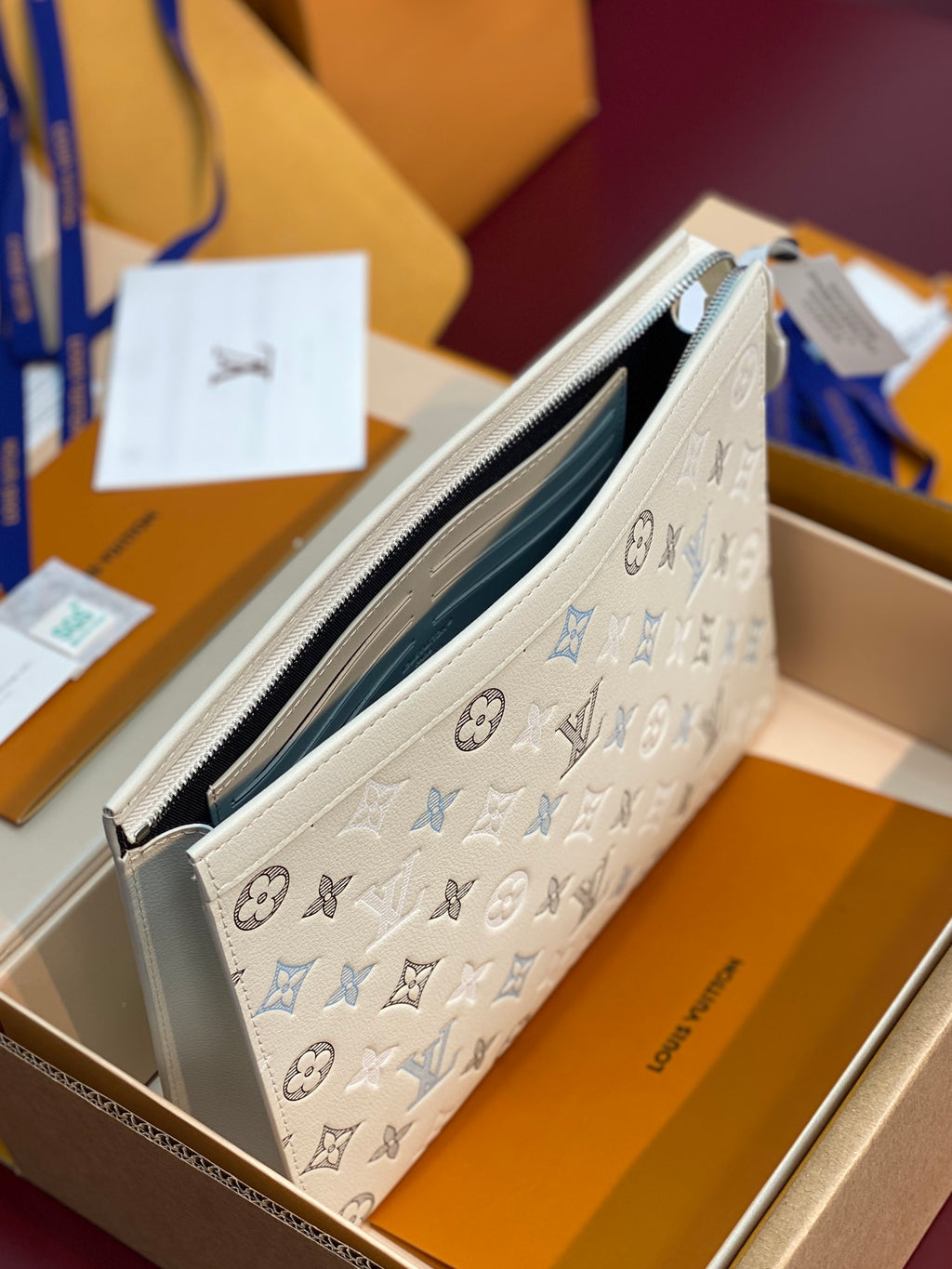 Light blue and white monogram Louis Vuitton pouch with open top and silver zipper