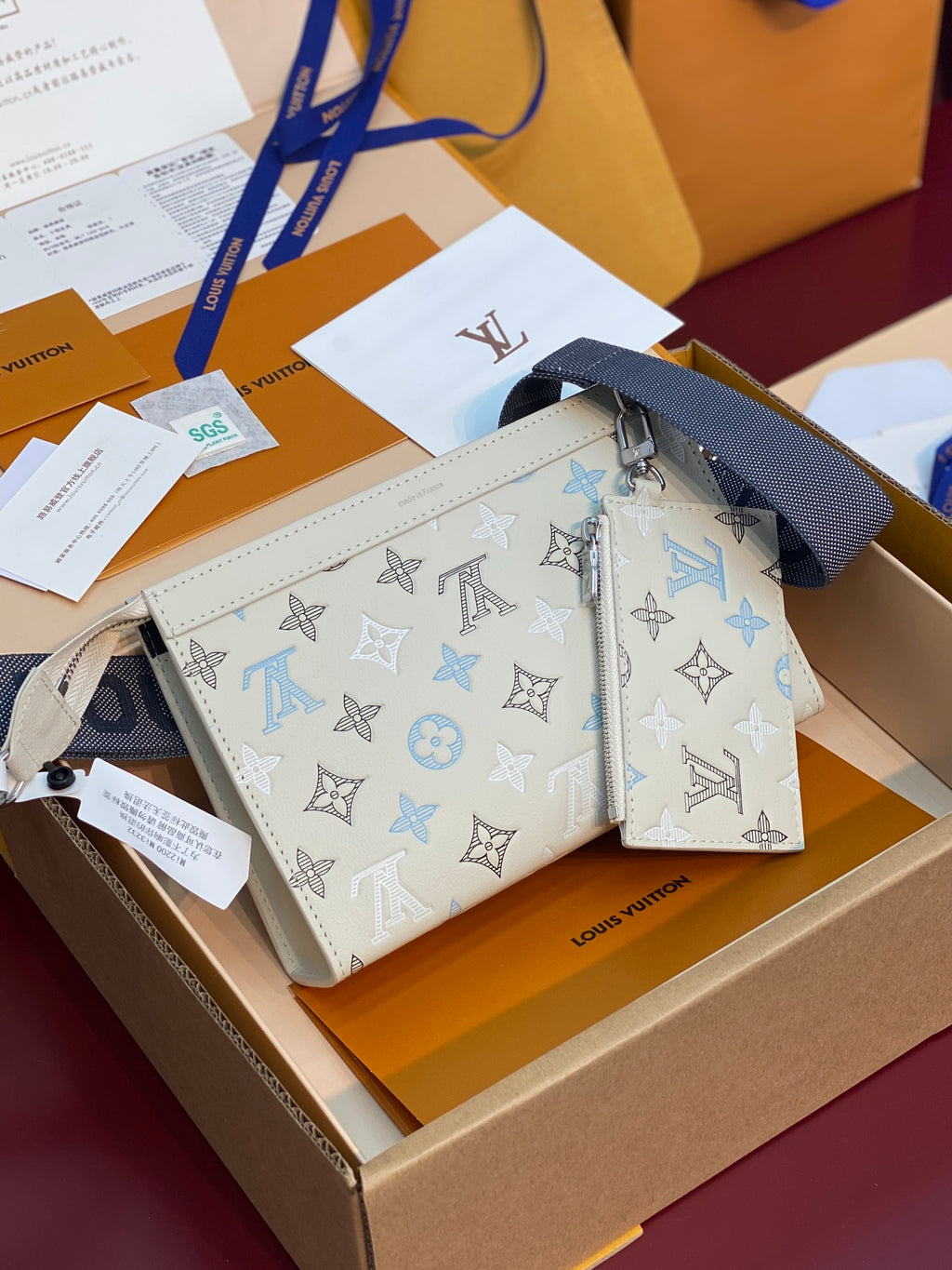 Louis Vuitton small bag with monogram pattern, white with blue trim, zip top and wrist strap