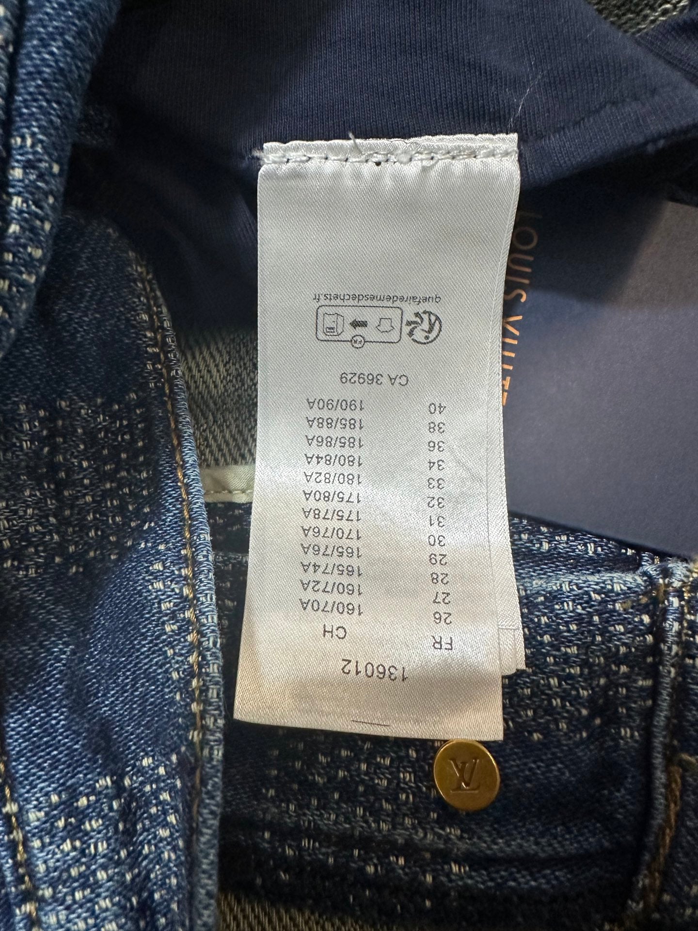 Denim pants size and care tag with gold button at waistband