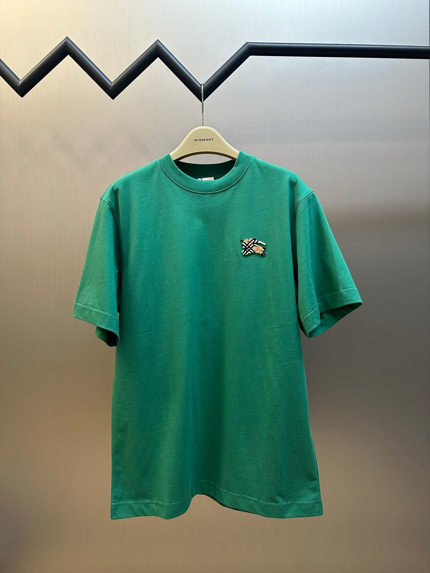 Green short-sleeve T-shirt with small embroidered crest on chest