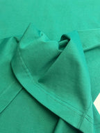 Green short-sleeve T-shirt showing shoulder seam and stitched edge