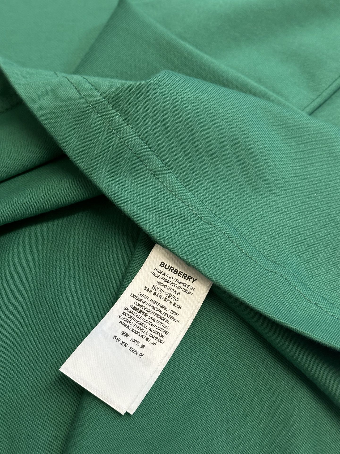 Green short-sleeve T-shirt with stitched hem and inner label tag