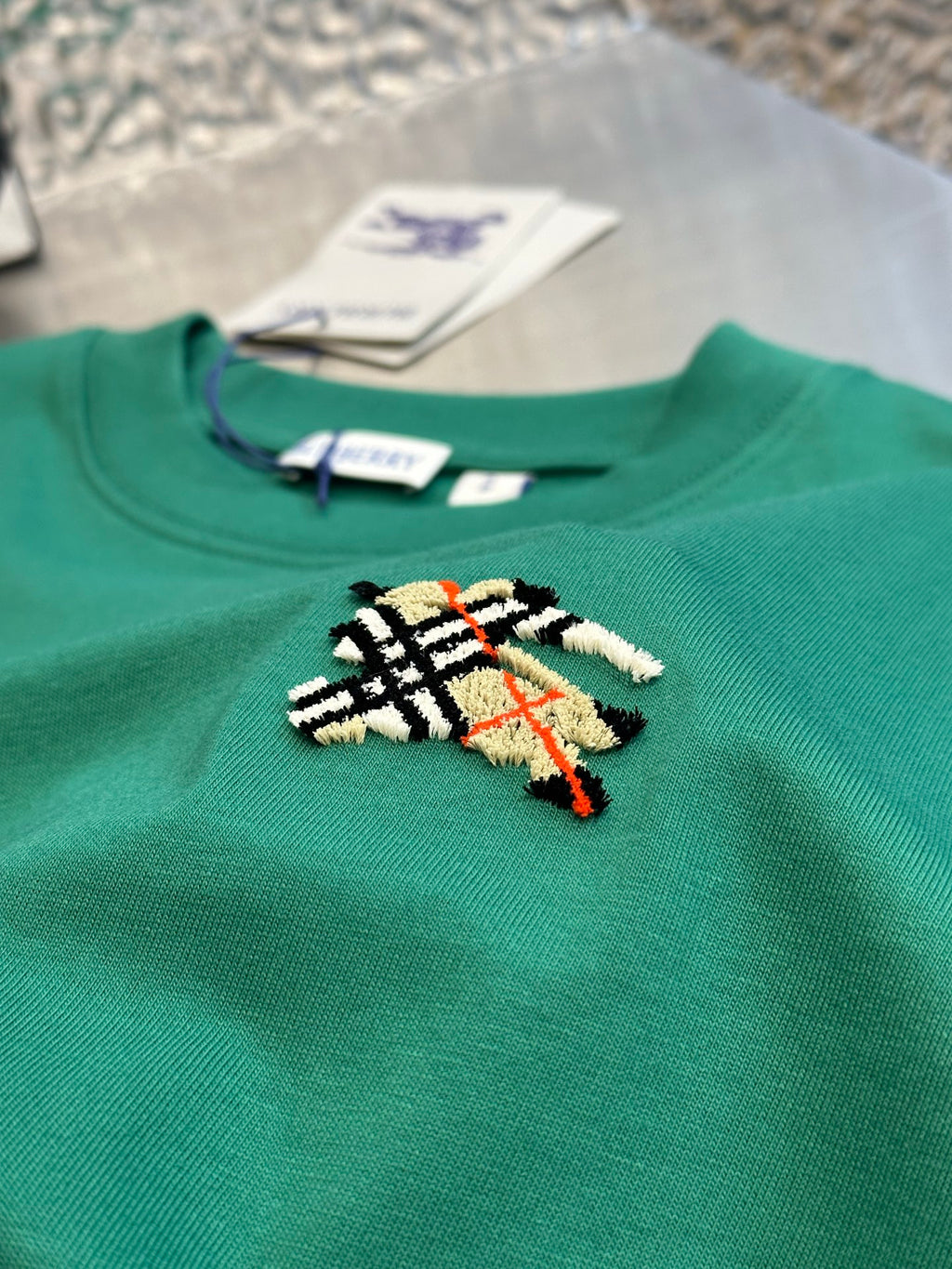 Green short-sleeve T-shirt with crewneck tag and embroidered crest