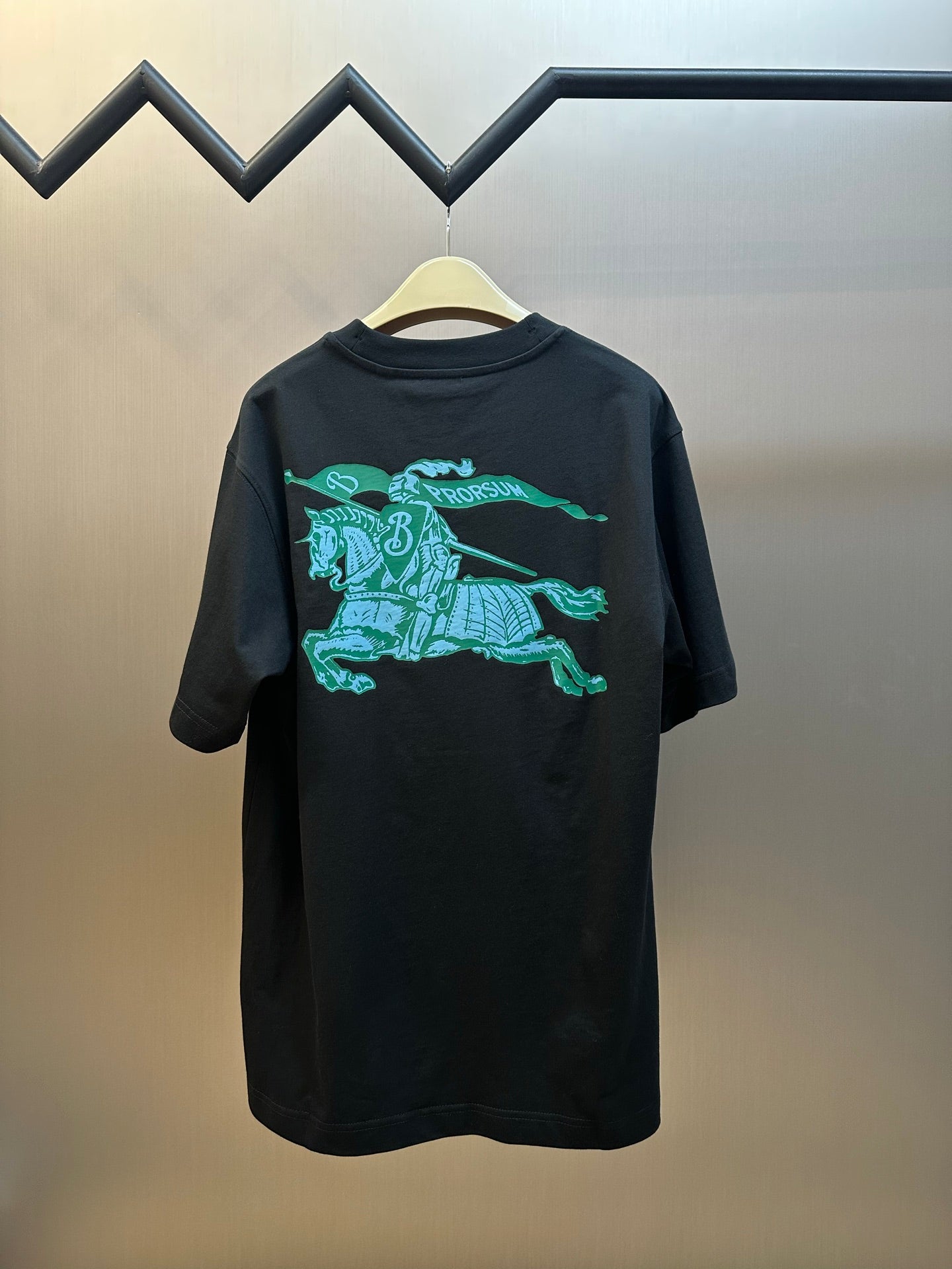 Black short-sleeve T-shirt with teal knight-and-horse graphic on back