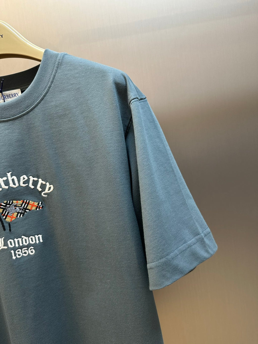 Blue short-sleeve T-shirt sleeve with partial embroidered logo graphic on chest