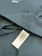 Blue T-shirt fabric with side seam and white product label under collar area