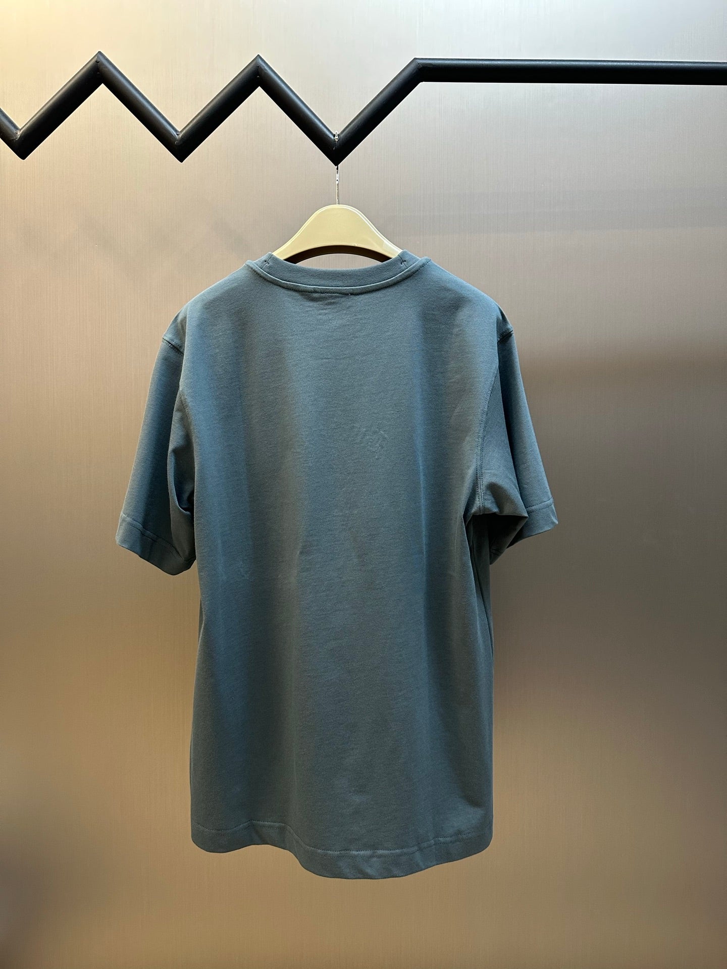 Blue short-sleeve T-shirt with crew neck, plain back view on hanger